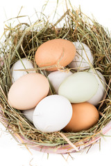 Easter basket filled with fresh and commercial eggs and hay