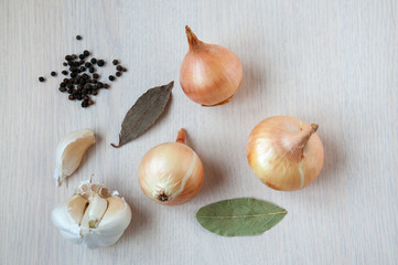 On the table, seasonings: onion, garlic, black pepper peas, bay leaf