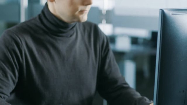 Young Male Industrial Engineer Works on a Personal Computer. Handsome Smart Man in the Bright Modern Office.Shot on RED EPIC-W 8K Helium Cinema Camera.