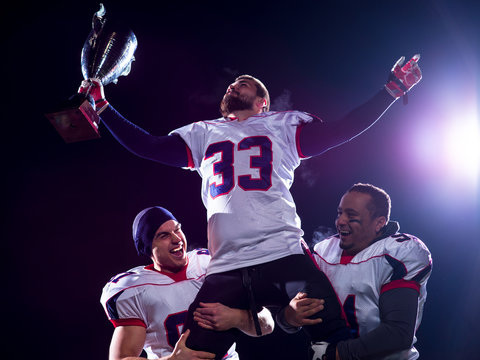 American Football Team With Trophy Celebrating Victory