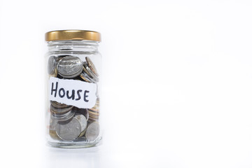 coins in a jar with a note written " HOUSE ". Isolated on a white background. Saving money to buy house. free copy space. Saving concept. Malaysia currency