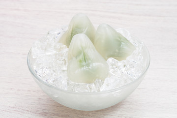 Matcha ice dumplings on ice cubes in bowl      