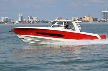 Fototapeta premium Well appointed sports fishing boat, red with white trim,cruising on the florida intra-coastal waterway off Miami Beach.