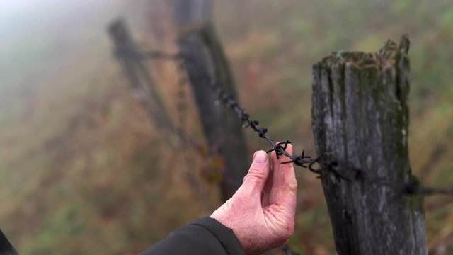 Man touches wire fence and goes into fog - (4K)