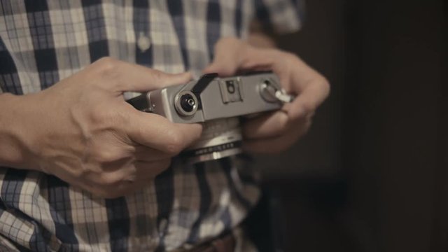 Close up male hand holding and close back of a film camera