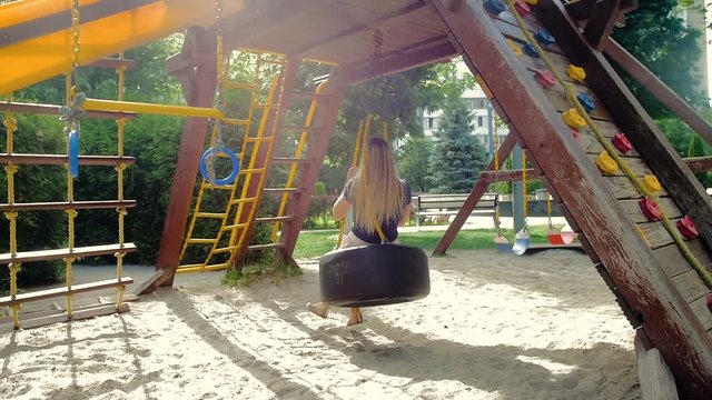 Slow motion video of happy smiling young woman having fun on playground at park