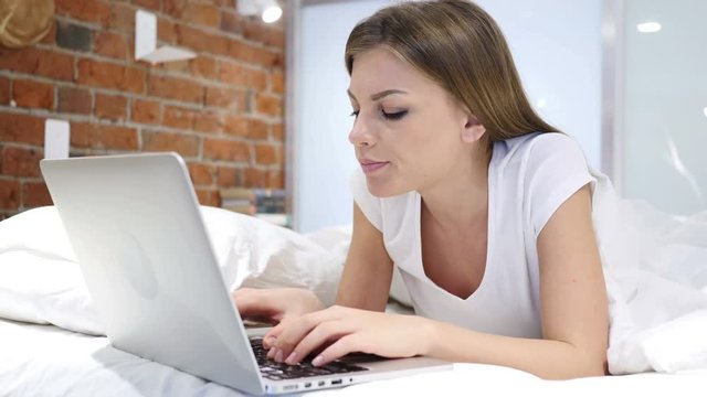 Thinking Pensive Woman in Bed Working on Laptop at Night