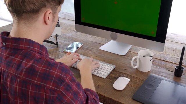 Top view of the freelancer male typing on wireless keyboard