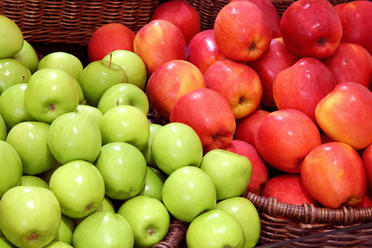 green apples and red apples in the basket at the supermarket