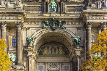 Details of the facade Berlin Cathedral ( Berliner Dom) on the Muzeum Island . Blue sky and yellow leaves on the trees.Berlin , Germany.