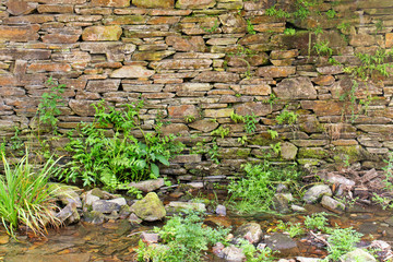 Ancient stone wall at a stream