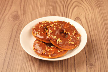 Chocolate ring cookies on a plate on wooden background