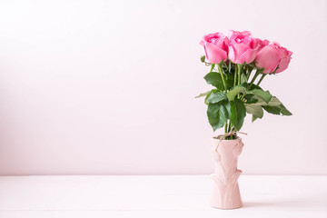 pink rose in vase on wood background