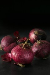 A group of fresh red onions on a dark background with copy space for your text
