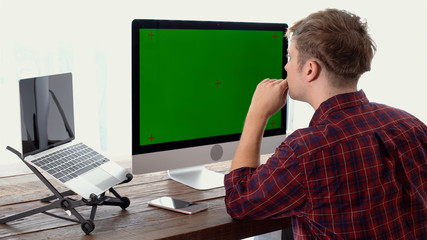 Young freelancer thinking during working with green screen display