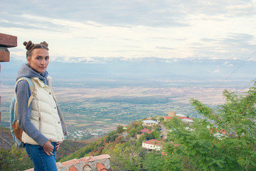 Naklejka premium So a beautiful woman is standing on top of a mountain with a backpack. Behind Alazani valley, Georgia. Sunset. Beautiful panorama. Cohete. Sighnaghi. Kontrazhur