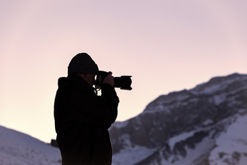 Nature photographer in winter mountains