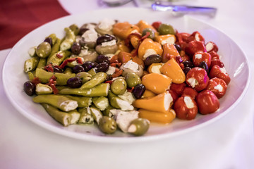 Antipasti Appetizer sweet cherry mini peppers stuffed with soft cheese feta on white plate