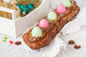 Traditional Greek Easter bread - tsoureki in Easter decorations with painted eggs and flowers.