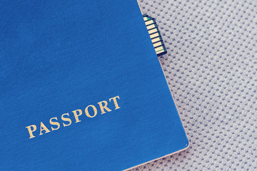 Blue Passport with memory card on a gray textile background