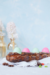 Traditional Greek Easter bread - tsoureki in Easter decorations with painted eggs and flowers.