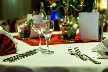Banquet with red table setting tablecloth white dishes silver cutlery glasses and decorations white copy text space card