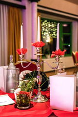 Banquet with red table setting tablecloth white dishes silver cutlery glasses and decorations white copy text space card