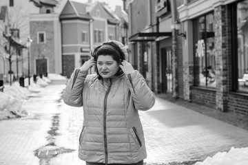 Fototapeta premium Plus size woman walk on a European old city street and goes shopping for fashion, gift and enjoys. Black Friday, Cyber Monday and Boxing Day, casual clothes for women. Lady thinking about something 