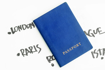 Blue passport on a white sheet background with the names of European capitals written by a black marker