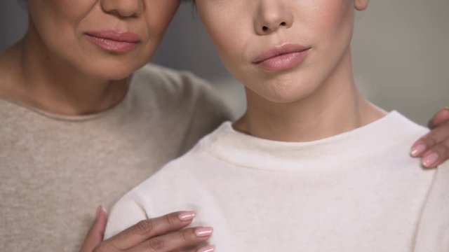 Two women support each other after loss of close person, attempt overcome pain