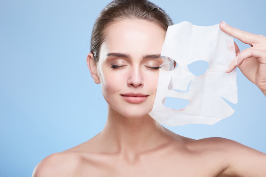 Woman removing mask from face