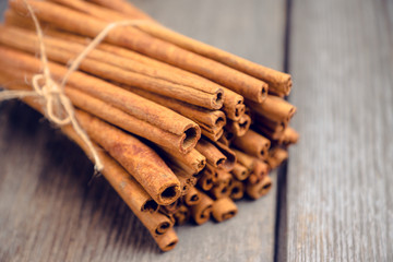 Cinnamon sticks on the rustic wooden background. Selective focus. Shallow depth of field.