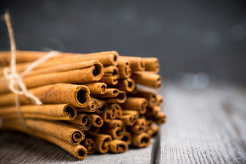 Cinnamon sticks on the rustic wooden background. Selective focus. Shallow depth of field.