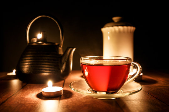 Tea service mug and teapot in candle light