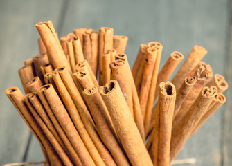 Cinnamon sticks on the rustic wooden background. Selective focus. Shallow depth of field. Toned image.
