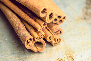Cinnamon sticks on the rustic wooden background. Selective focus. Shallow depth of field. Toned image.
