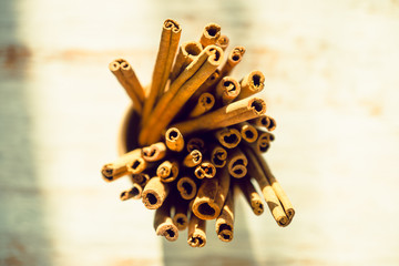 Cinnamon sticks on the rustic wooden background. Selective focus. Shallow depth of field. Toned image.