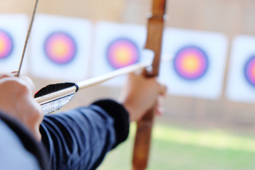 Archer holds his bow aiming at a target