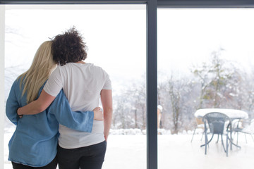 young couple enjoying morning coffee by the window
