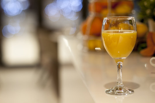 Glass with orange juice on the bar in the restaurant