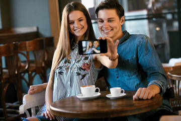 Friends Taking Photos With Coffee In Cafe.