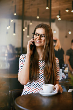 Woman In Cafe Talking On Mobile Phone