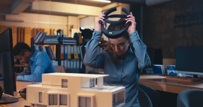 Caucasian female professional architect using augmented reality AR hololens headset to work on a house project. 4K UHD RAW edited footage