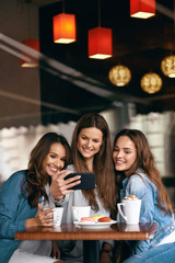 Beautiful Girls In Cafe Taking Selfie Photo On Phone.