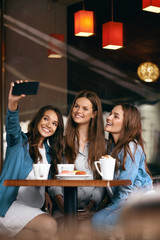 Beautiful Girls In Cafe Taking Selfie Photo On Phone.