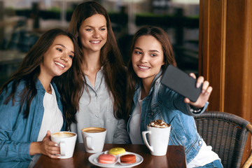 Beautiful Girls In Cafe Taking Selfie Photo On Phone.