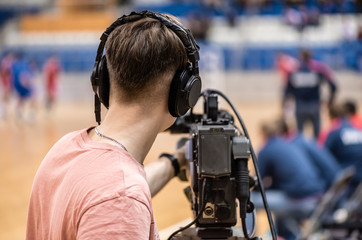 video operator recording a sports match on a professional video camera
