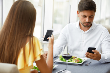 Communication Problem. Man And Woman With Phones On Date