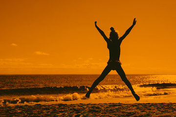 photo of a girl jumping on the beach