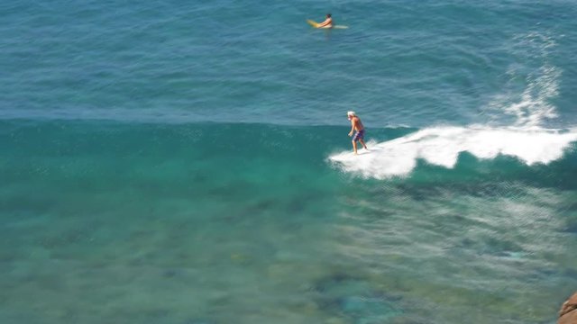 high angle view of a surfer riding a longboard at honolua bay, maui